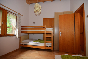 Schlafzimmer mit drei Betten (ein Stockbett, ein Einzelbett)